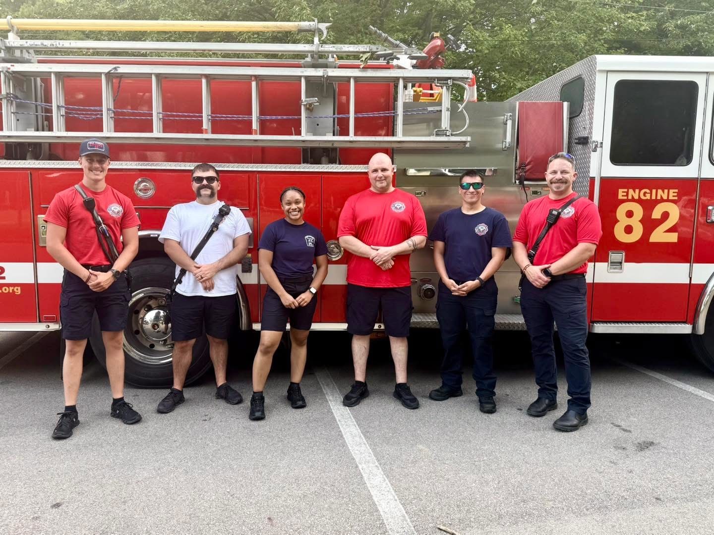 Six Miami Township Fire-Rescue firefighters and medics standing together in front of Engine 82.
